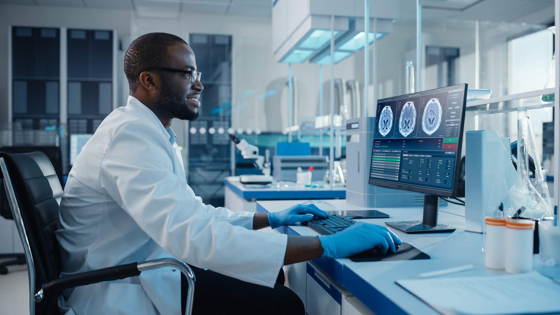 Lab technician reviewing brain scan images on a monitor