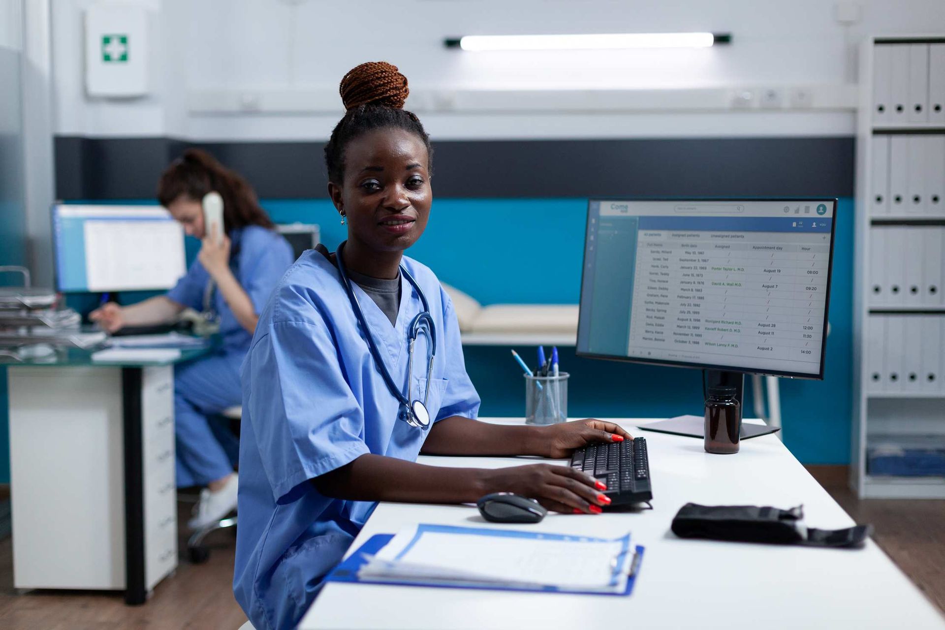 A nurse working confidently at a computer workstation in an African healthcare facility